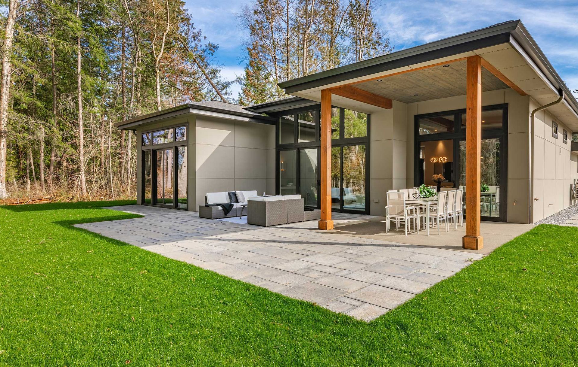 A pergola with a couch and chairs underneath it