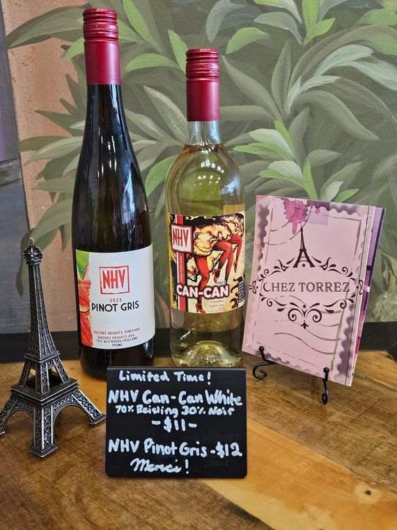 Two bottles of wine are sitting next to each other on a table.