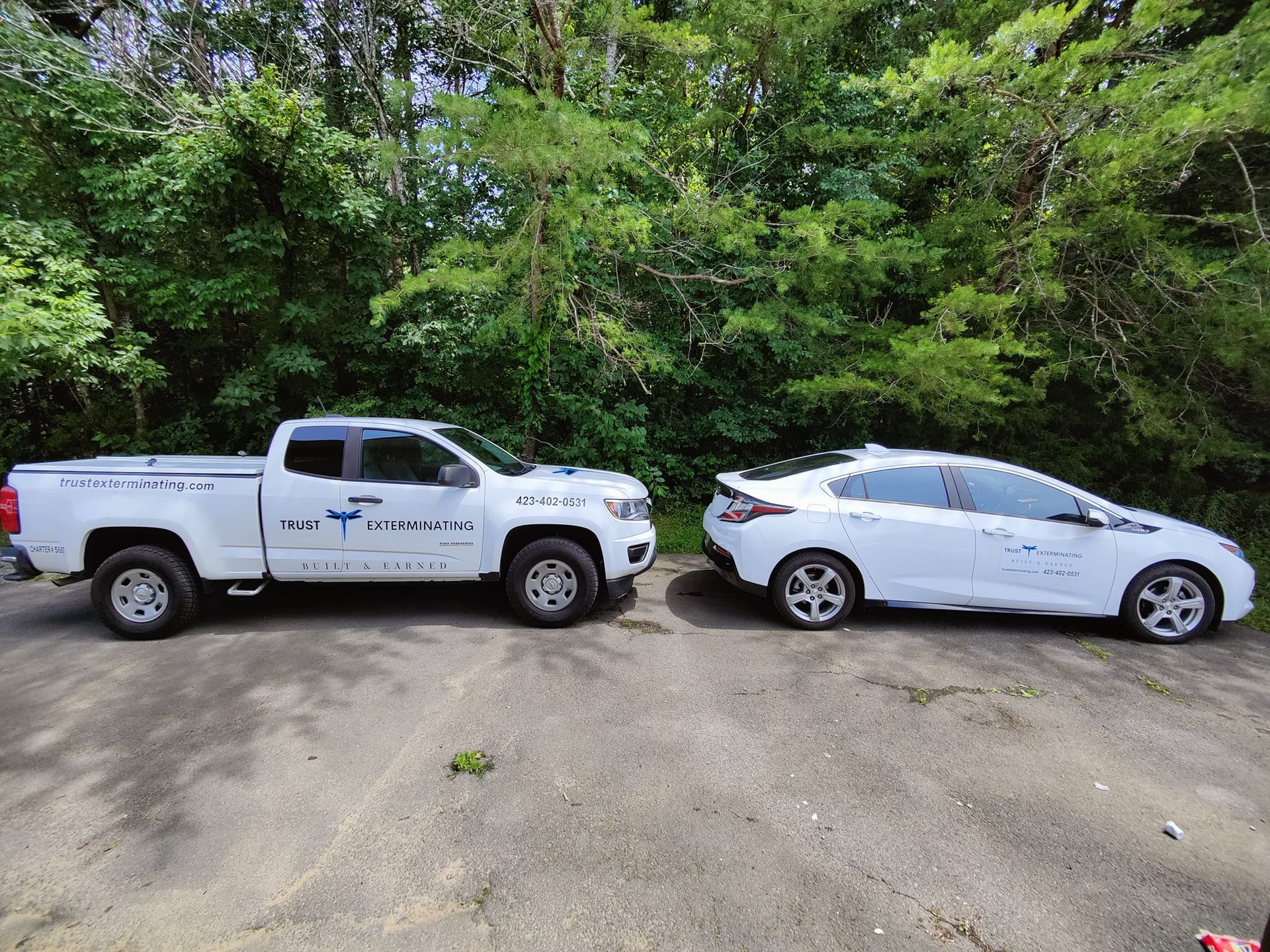 Two white cars are parked next to each other in a parking lot.
