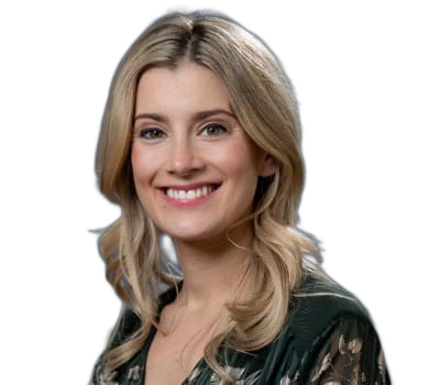 A smiling blonde woman with fair skin and light eyes poses