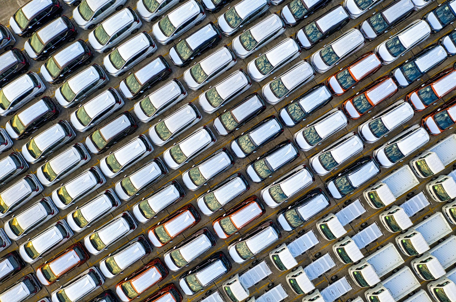 An aerial view of a parking lot filled with lots of cars.