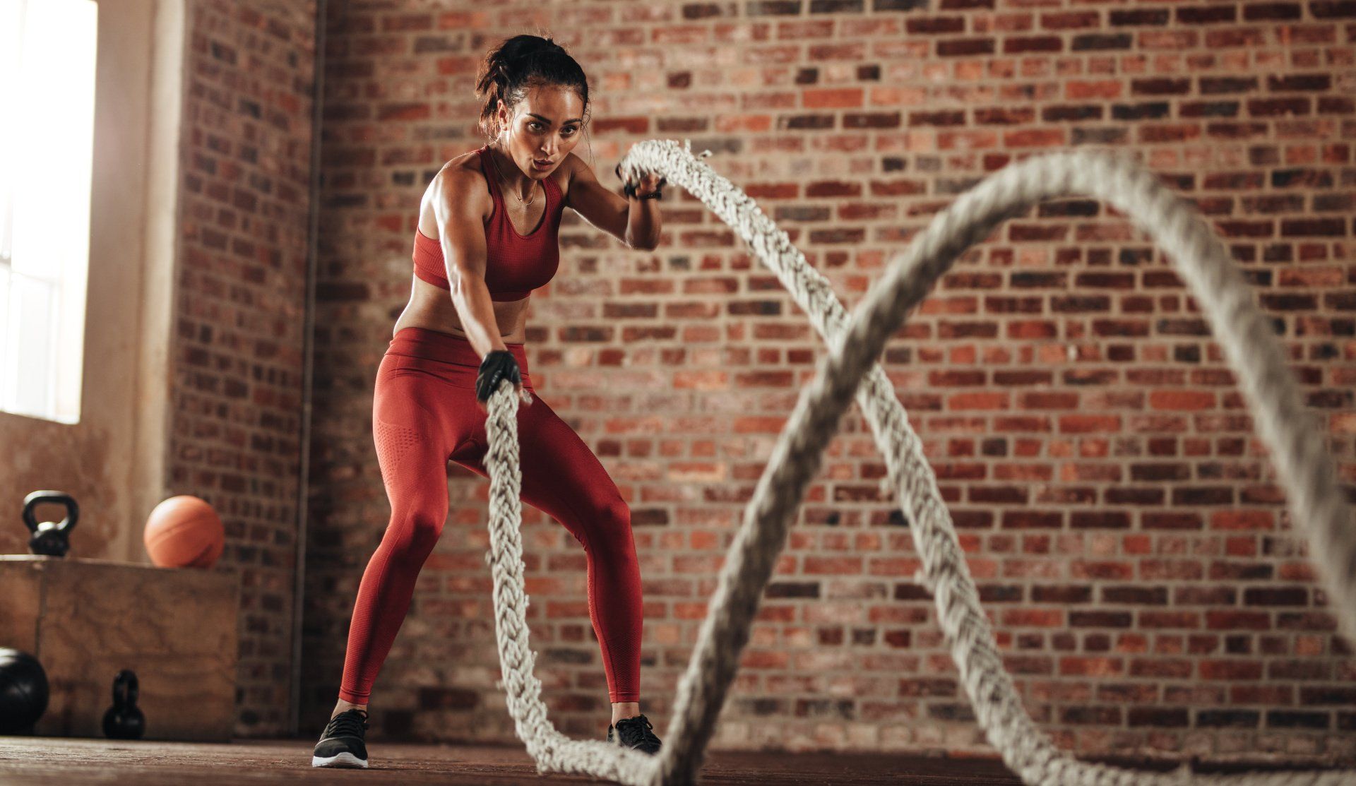 A woman working out with battle ropes