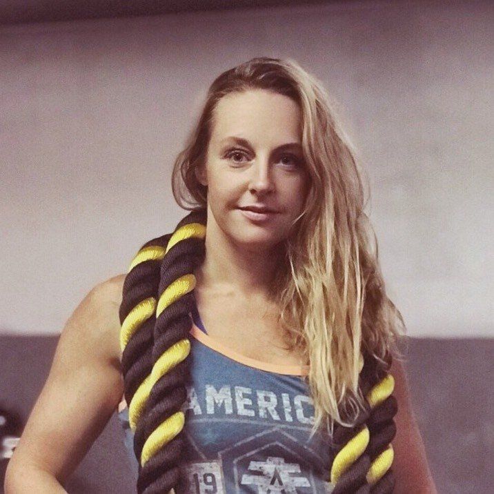 Stephanie Kosnick, Inferno's Owner, is wearing a blue tank top with weighted workout ropes draped over her shoulders