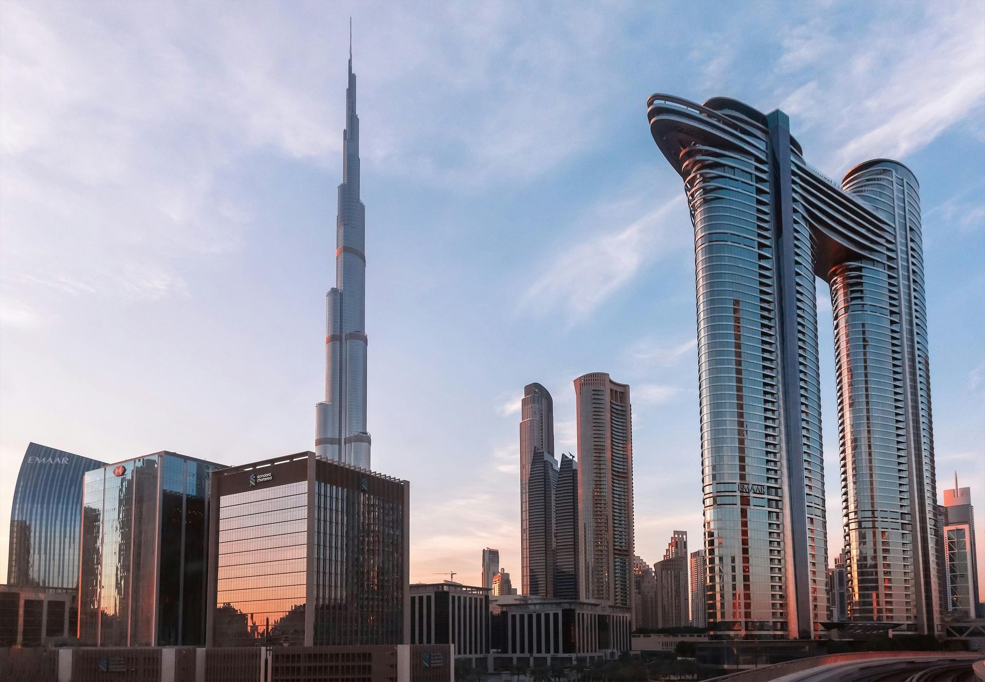Dubai skyline at sunset with the Burj Khalifa and modern glass skyscrapers
