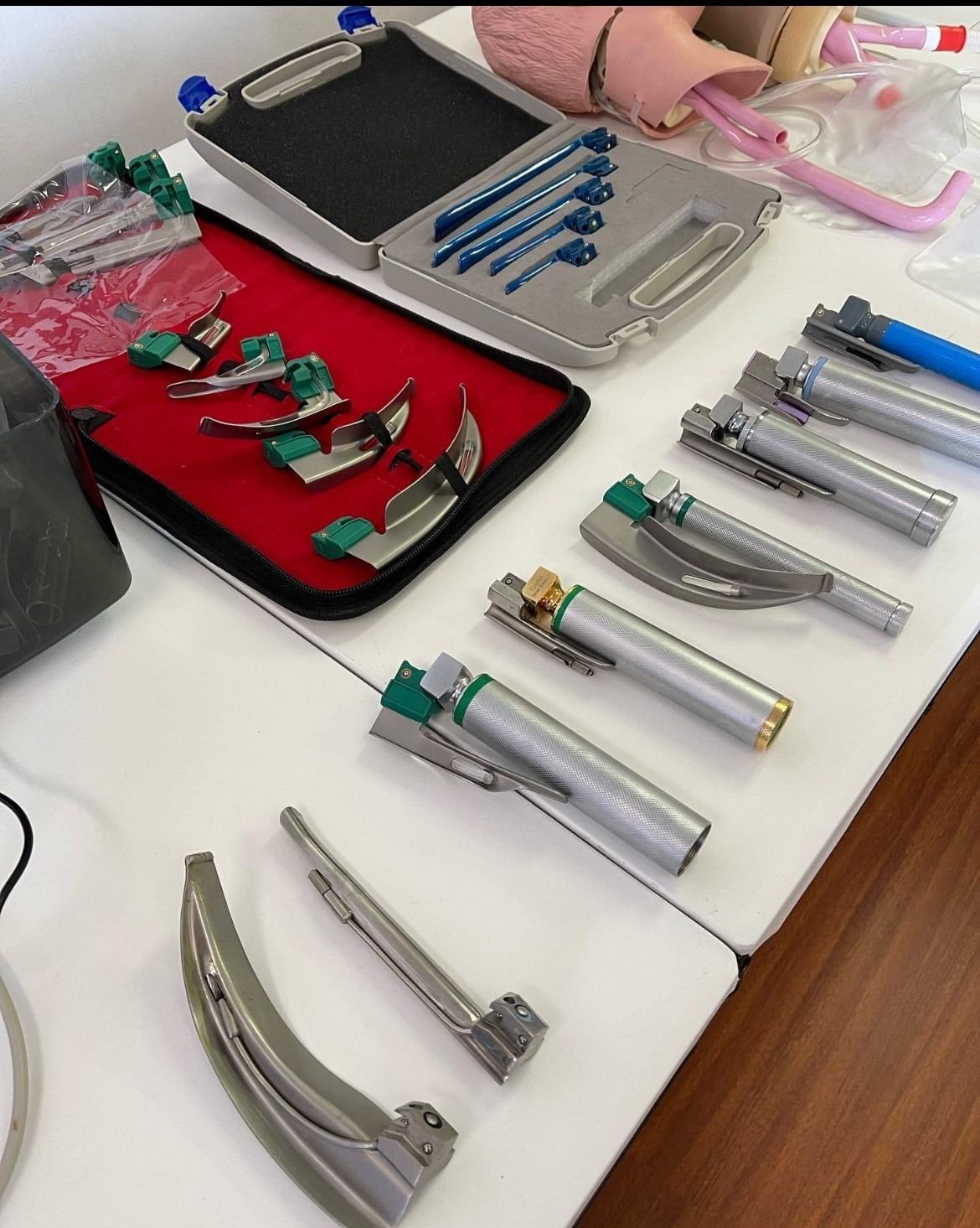 A bunch of laryngoscopes are lined up on a table