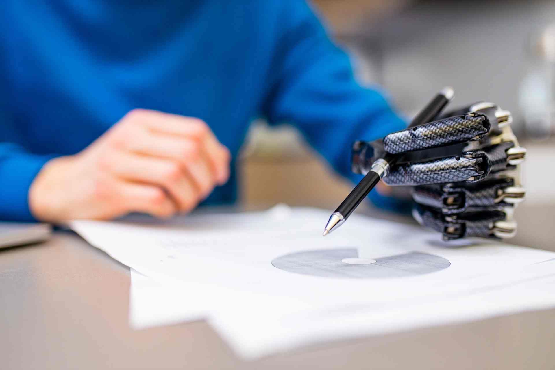 Man with prosthetic hand holding a pen near Edgewood, KY, and Lawrenceburg, IN