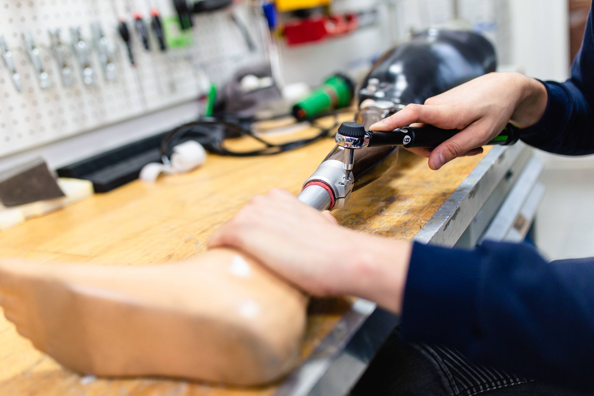 Prosthetic specialist working on a prosthetic leg on a bench at Durrett's Orthotic & Prosthetic near Edgewood, KY, and Lawrenceburg, IN