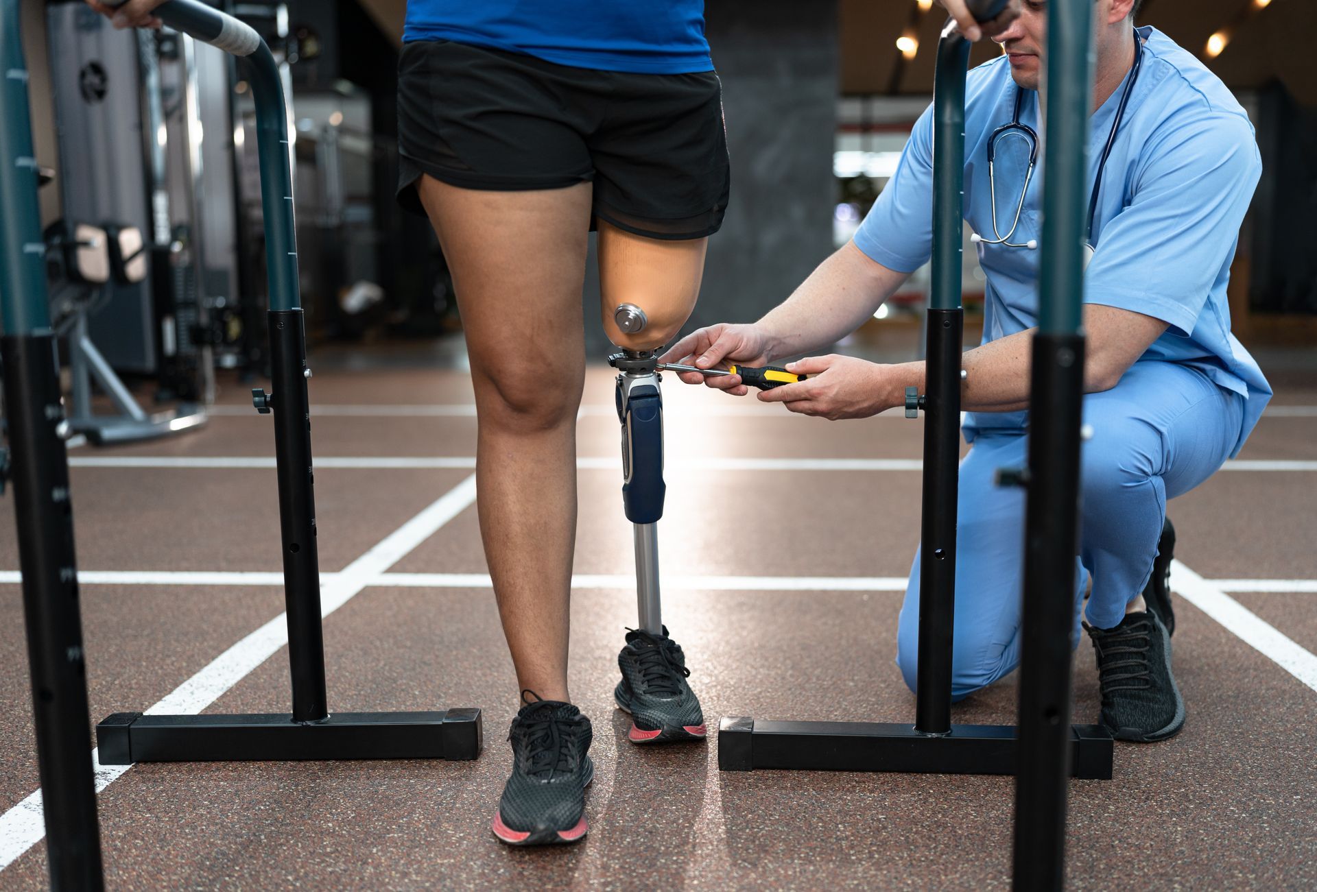 Prosthetics professional tightening a prosthetic leg in an activity room.