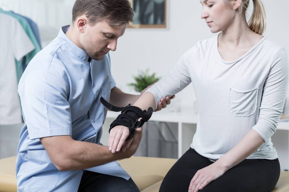 Specialist helping a person fit a wrist orthosis in a waiting room near Edgewood, KY