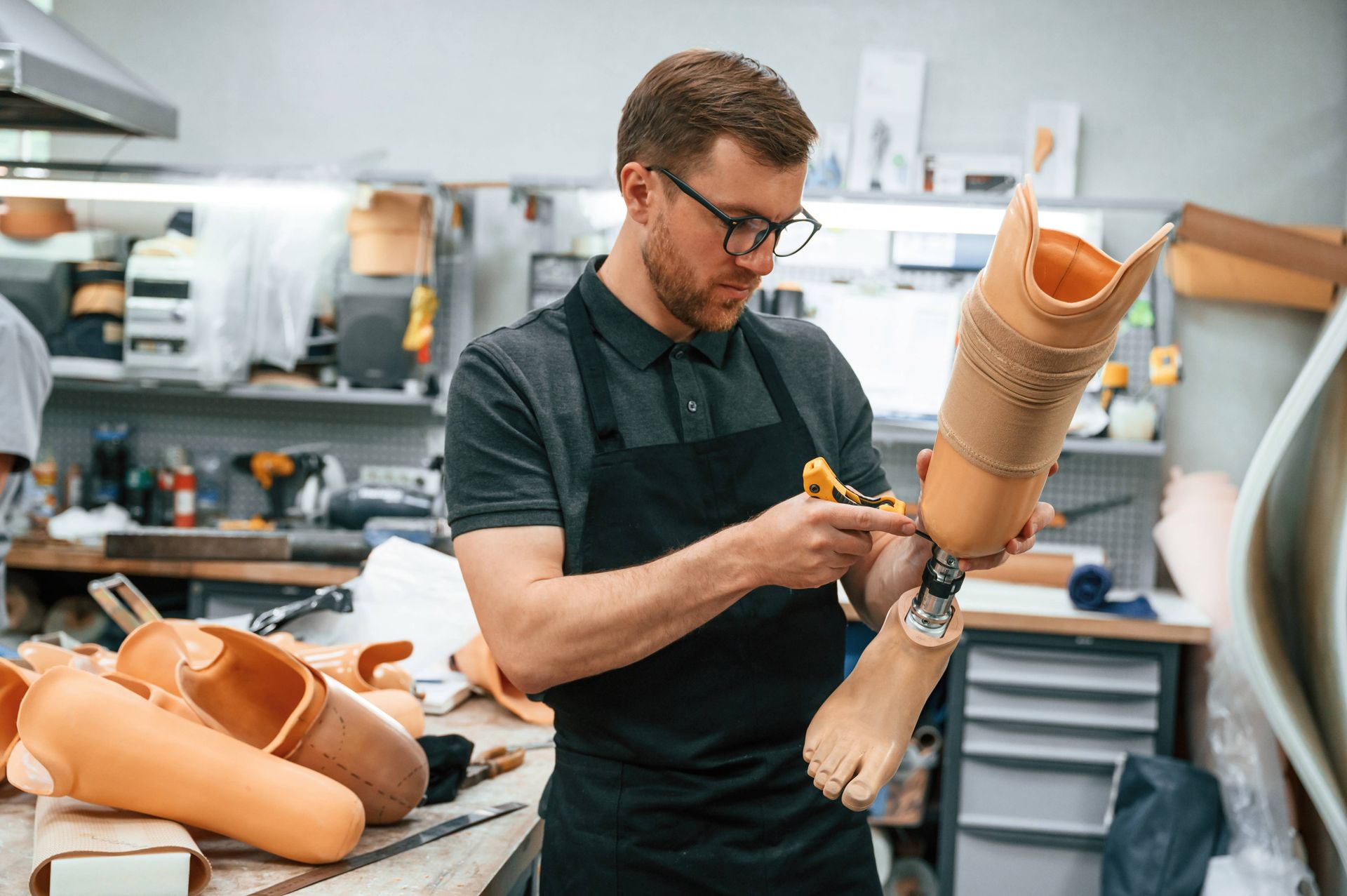 A prosthetist tightening the screws on a prosthetic leg in workshop near Edgewood, KY, and Lawrenceburg, IN