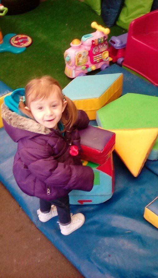toddler in purple jacket playing outside