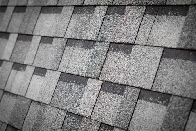 A black and white photo of a roof with shingles.