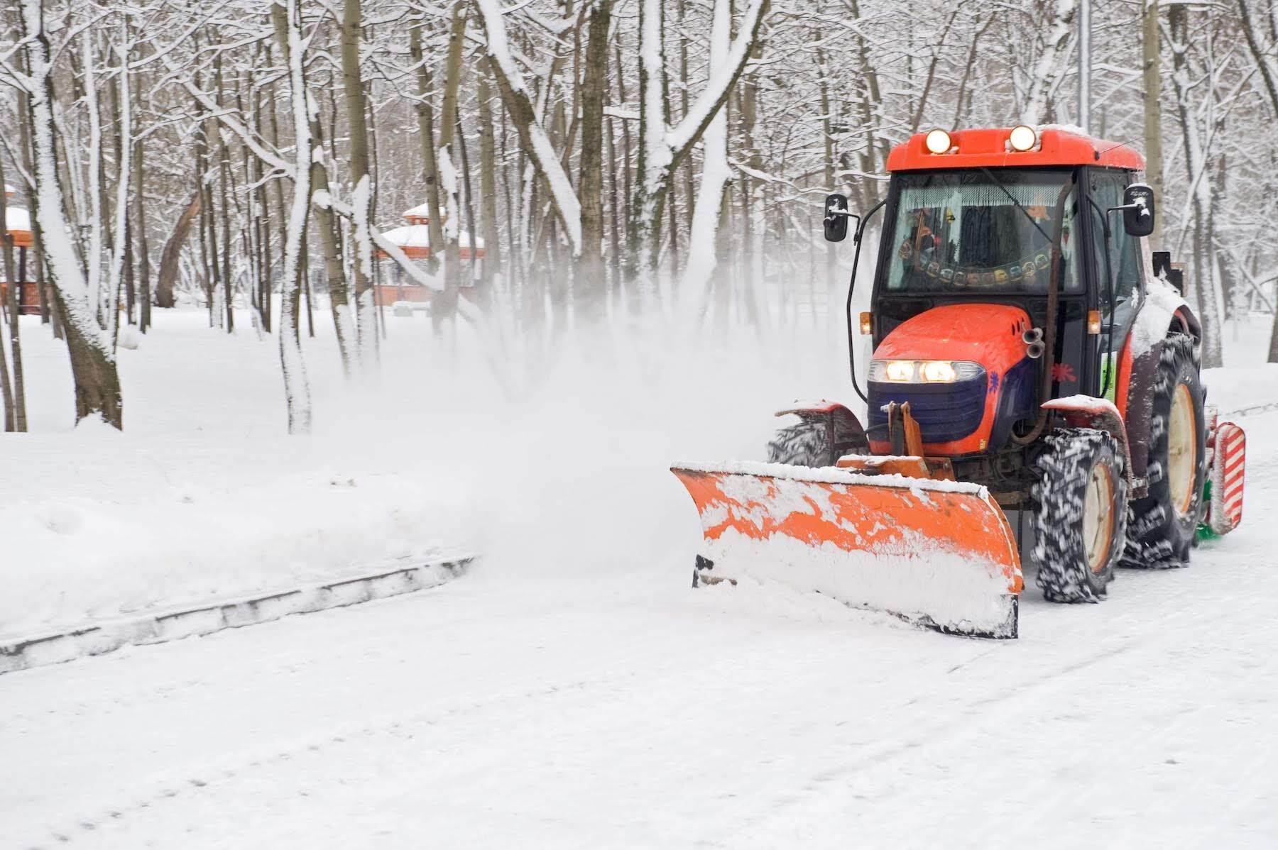 Snow removal machine clearing a snow-covered road during winter operations.