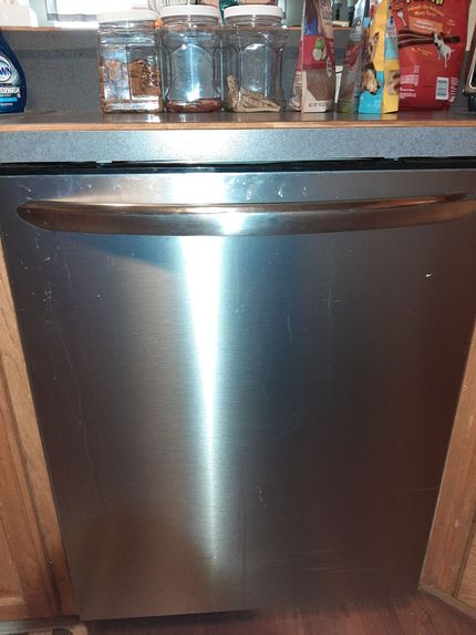 a stainless steel dishwasher is sitting on a counter in a kitchen .