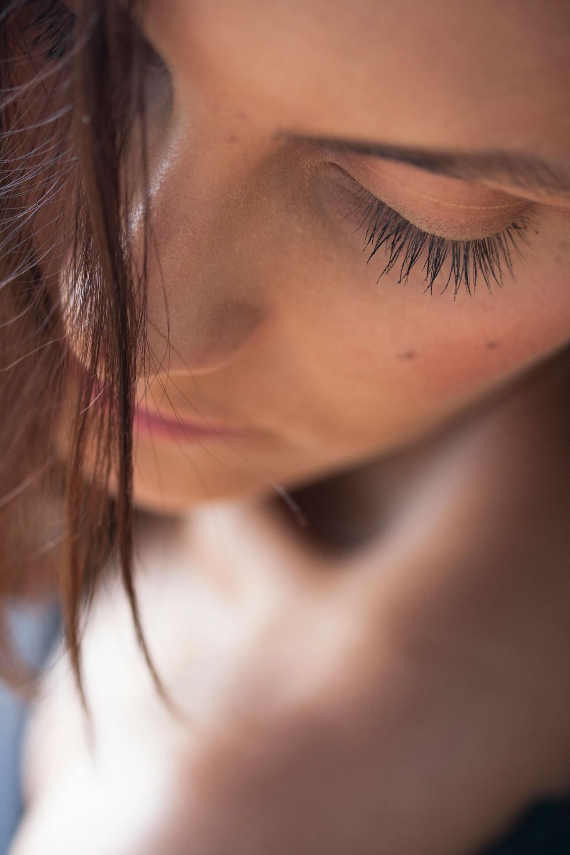 A close up of a woman 's face with her eyes closed.