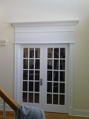 A room with a staircase and french doors