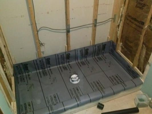 A shower stall is being built in a bathroom.