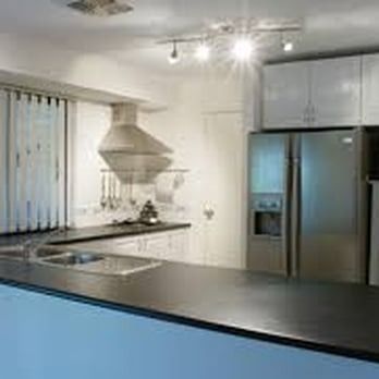A kitchen with a stainless steel refrigerator , sink , and stove.