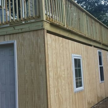 A wooden house with a balcony on top of it