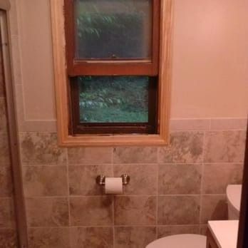 A bathroom with a toilet , sink , and window.