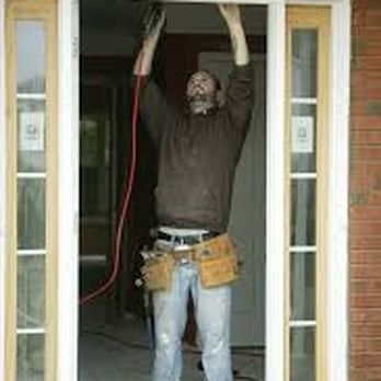 A man is working on a sliding glass door.
