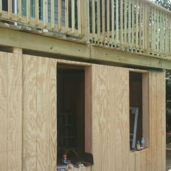 A wooden building under construction with a balcony above it