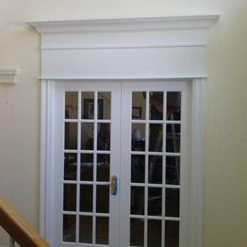 A white french door with a wooden railing in front of it