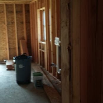 A room under construction with a trash can in the middle