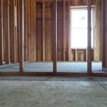 An empty room with wooden walls and a window.