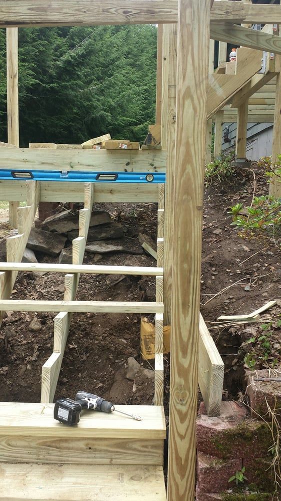 A drill is sitting on top of a wooden staircase under construction.