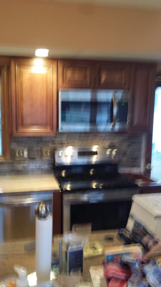 A kitchen with stainless steel appliances and wooden cabinets.