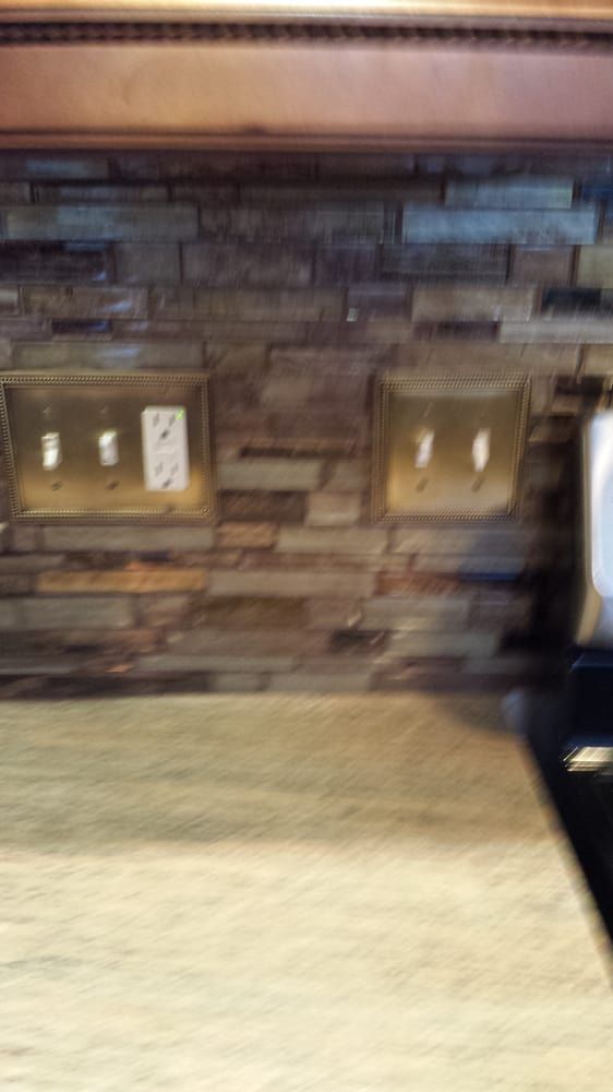 A kitchen with a brick wall and a wooden counter top.
