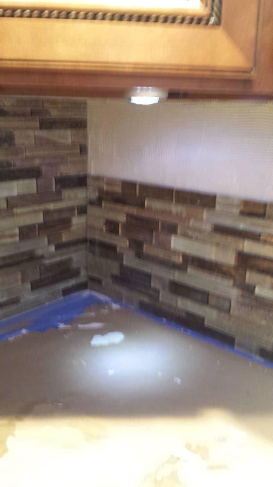 A kitchen with a brick wall and a light on the ceiling.