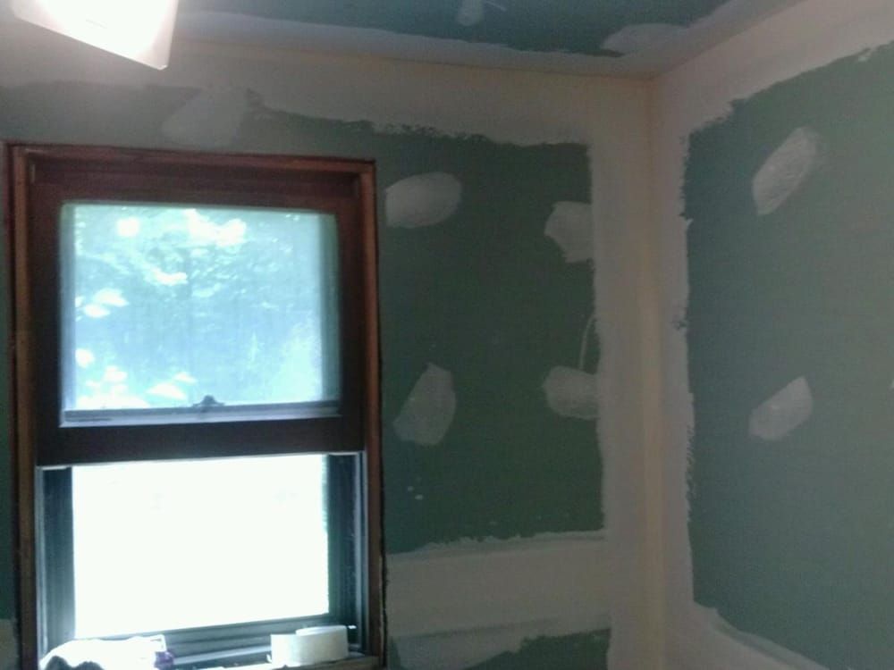 A room with a window and green walls