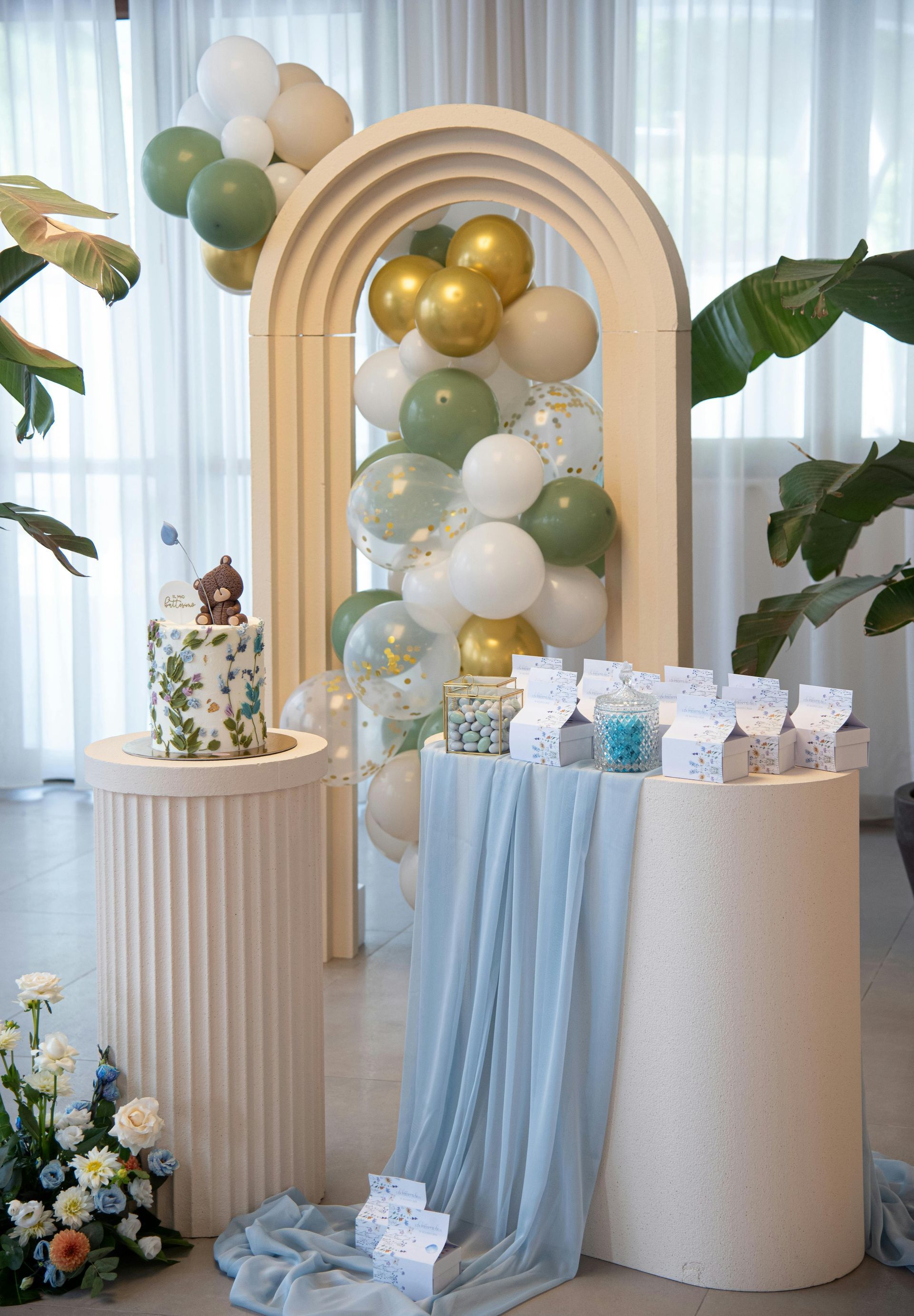 A table with a cake and balloons on it.