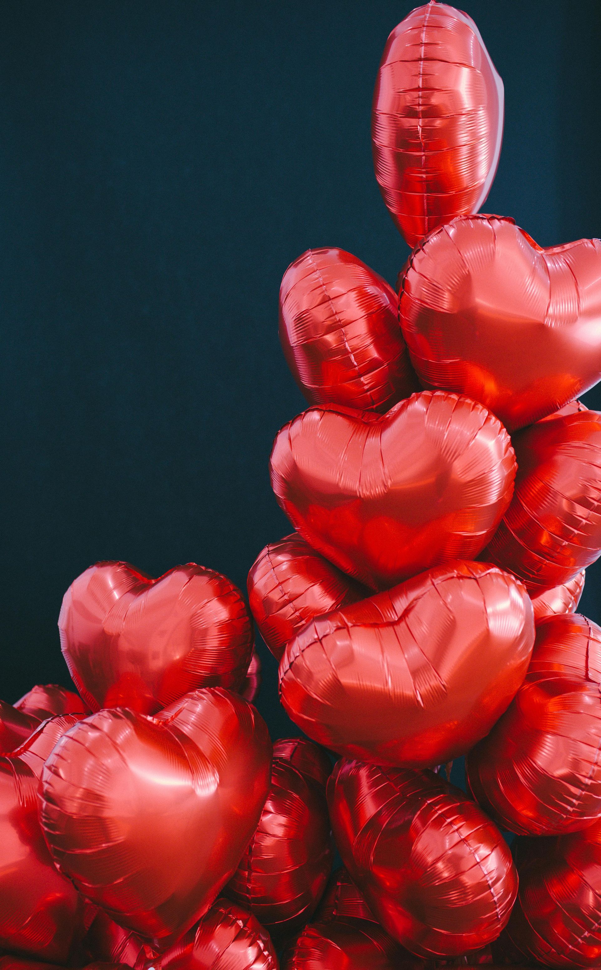 A bunch of red heart shaped balloons stacked on top of each other.