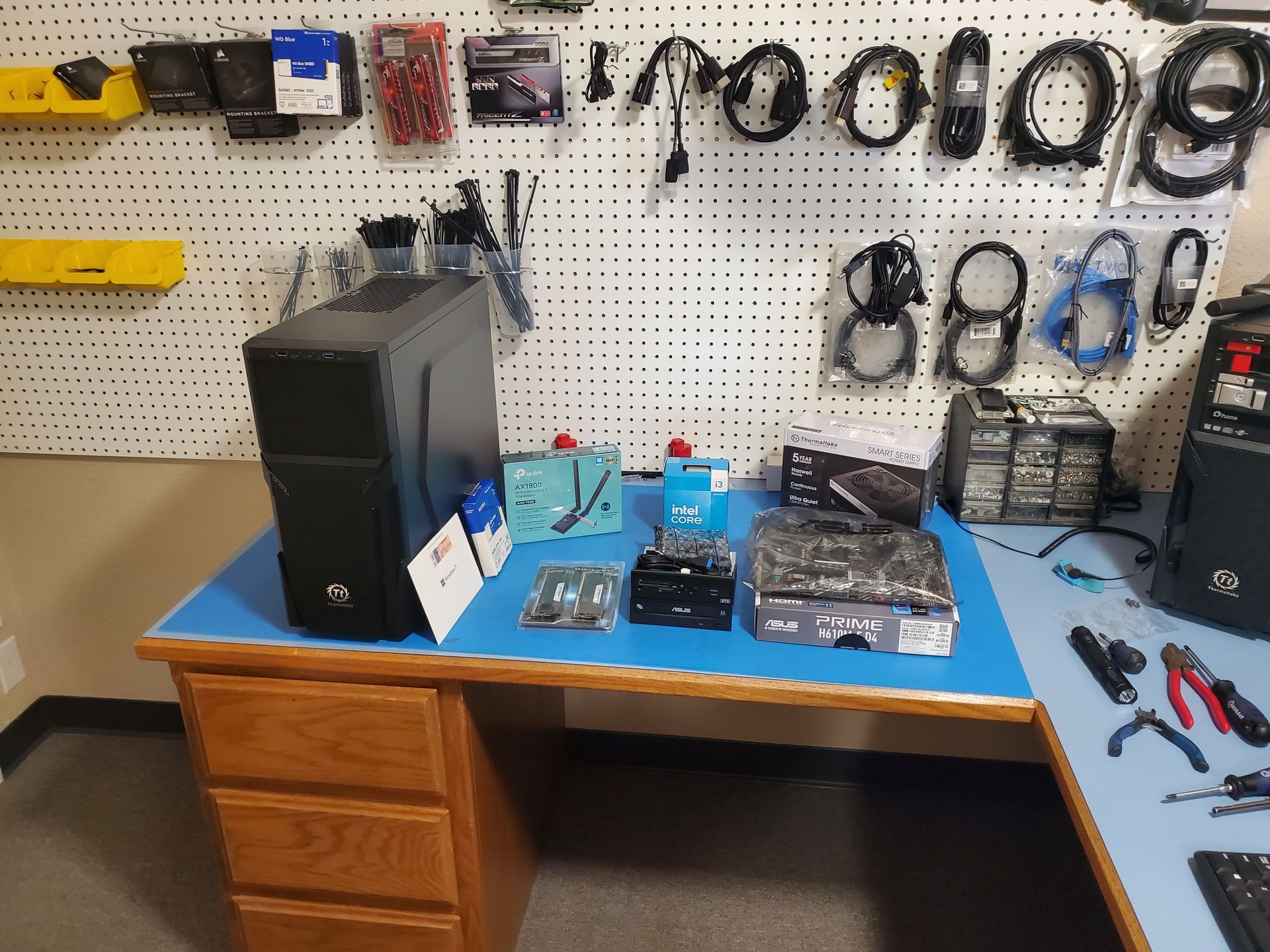A computer is sitting on a blue desk in a workshop.