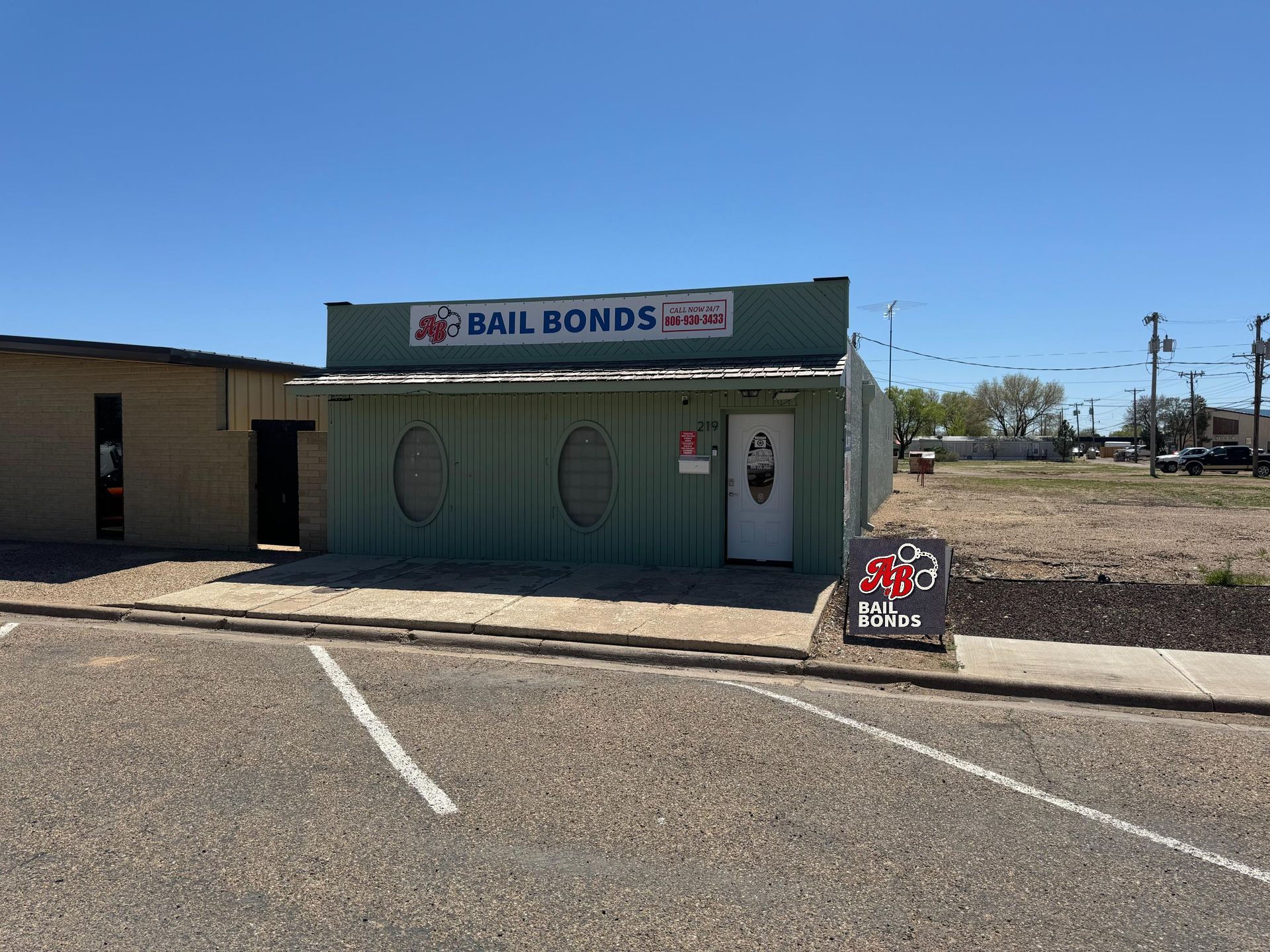 Green bail bonds office with red logo on a sunny day.