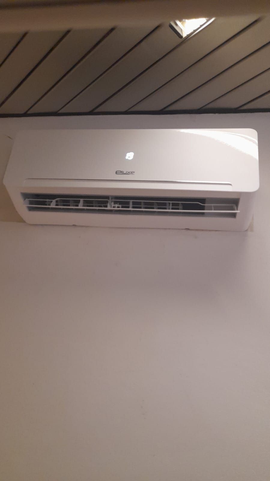 Un condizionatore bianco è appeso alla parete di una stanza.