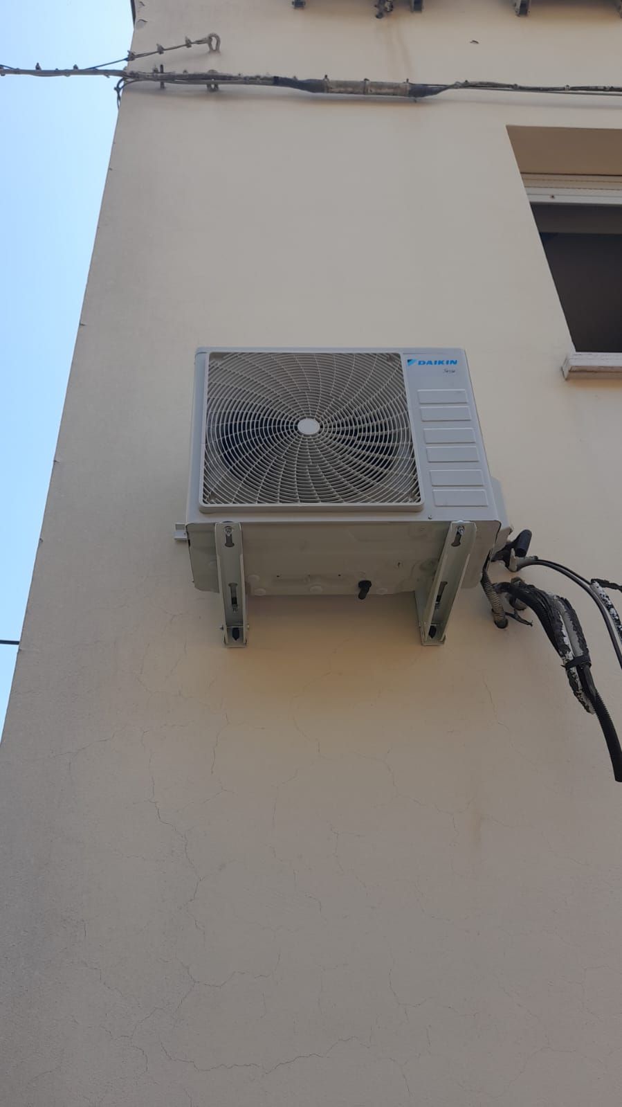 Un condizionatore bianco è montato sul lato di un edificio.