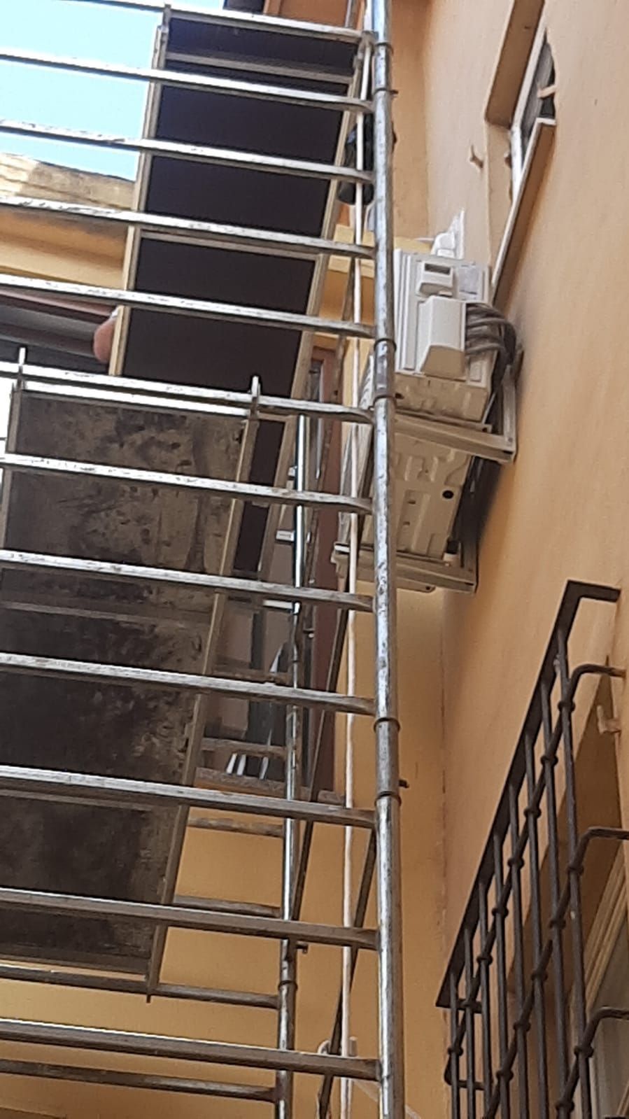 Una scala è fissata al lato di un edificio.