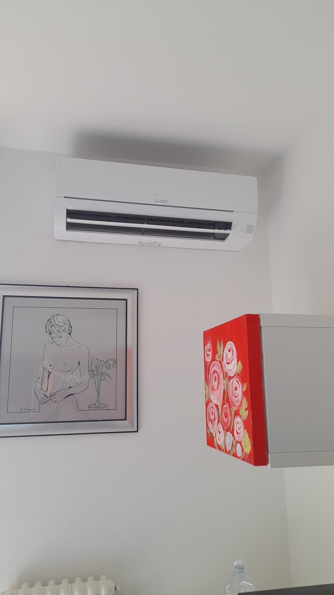 C'è un quadro sul muro accanto al condizionatore.