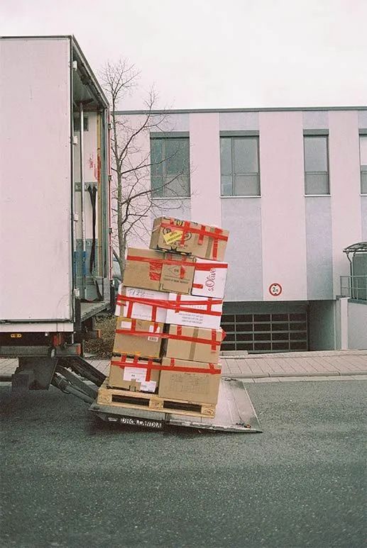 A Truck Is Loading Boxes On A Pallet In Front Of A Building — Local & Country Removals in Helensvale, QLD
