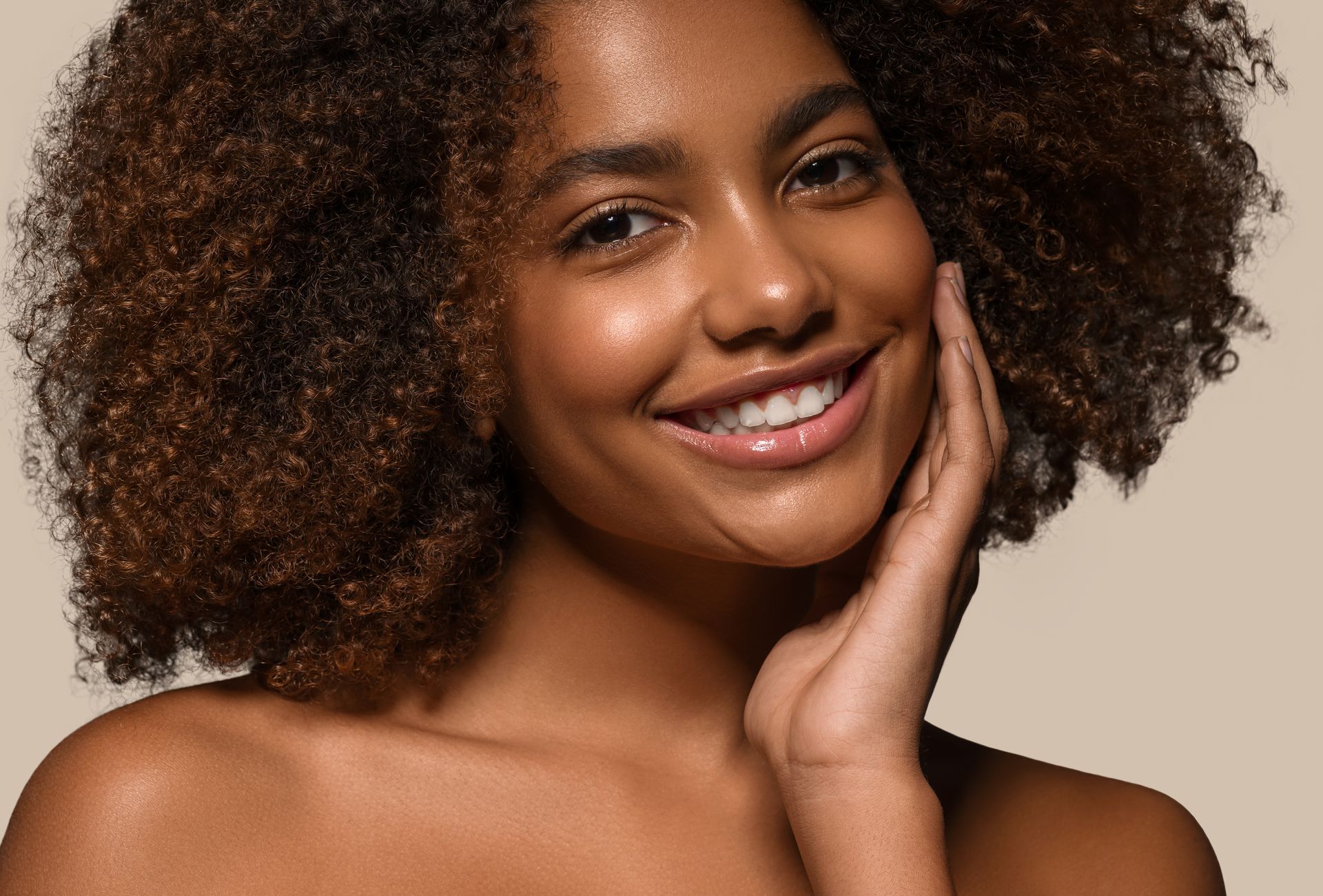Woman with curly brown hair smiling.