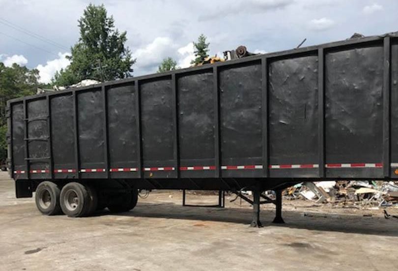 A large black trailer is parked in a parking lot