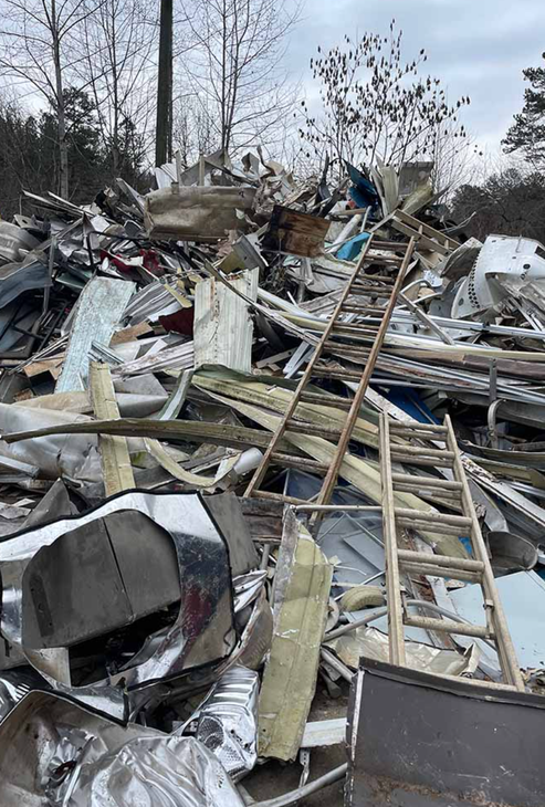 A pile of scrap metal with a ladder in the middle of it.