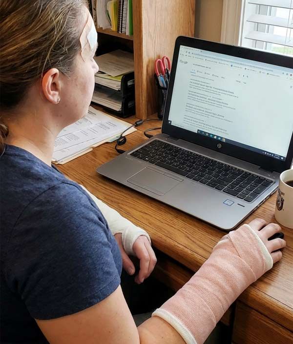 A womn with two broken wrists on a computer looking for a personal injury lawyer on Google