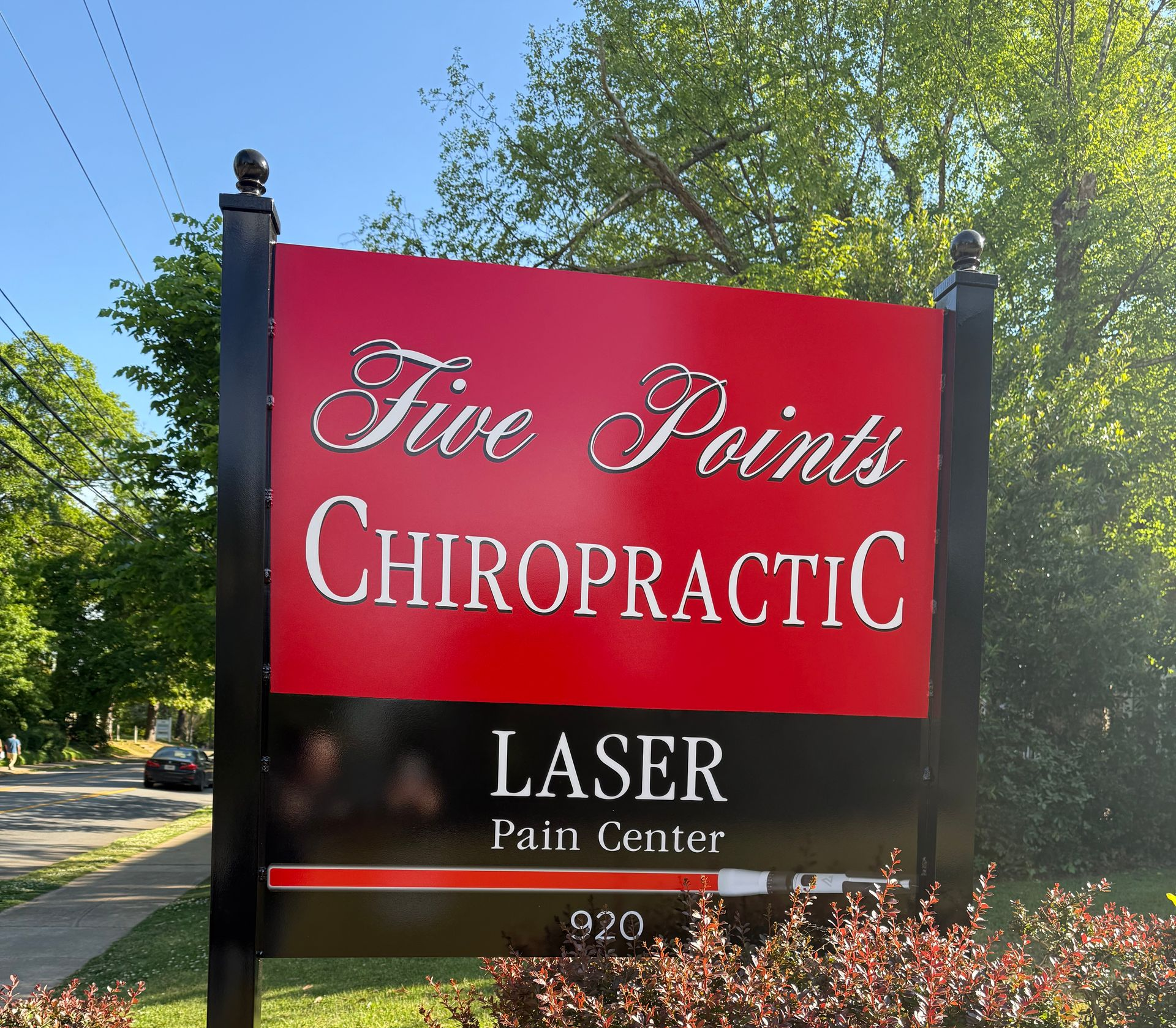 Five Points Chiropractic sign with black and red panels and “Laser Pain Center” text outdoors.