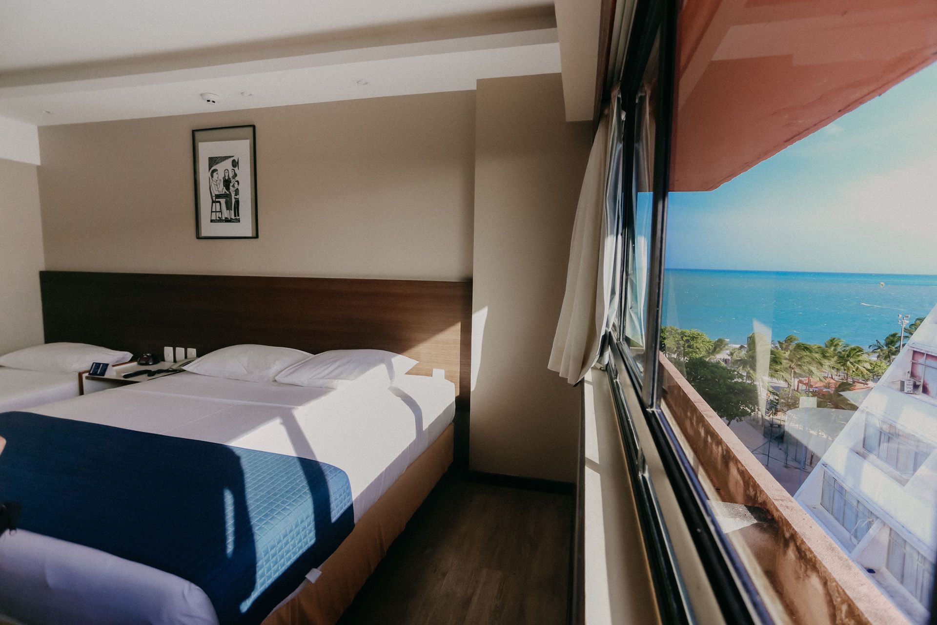 Quarto de hotel com cama e vista para o mar.