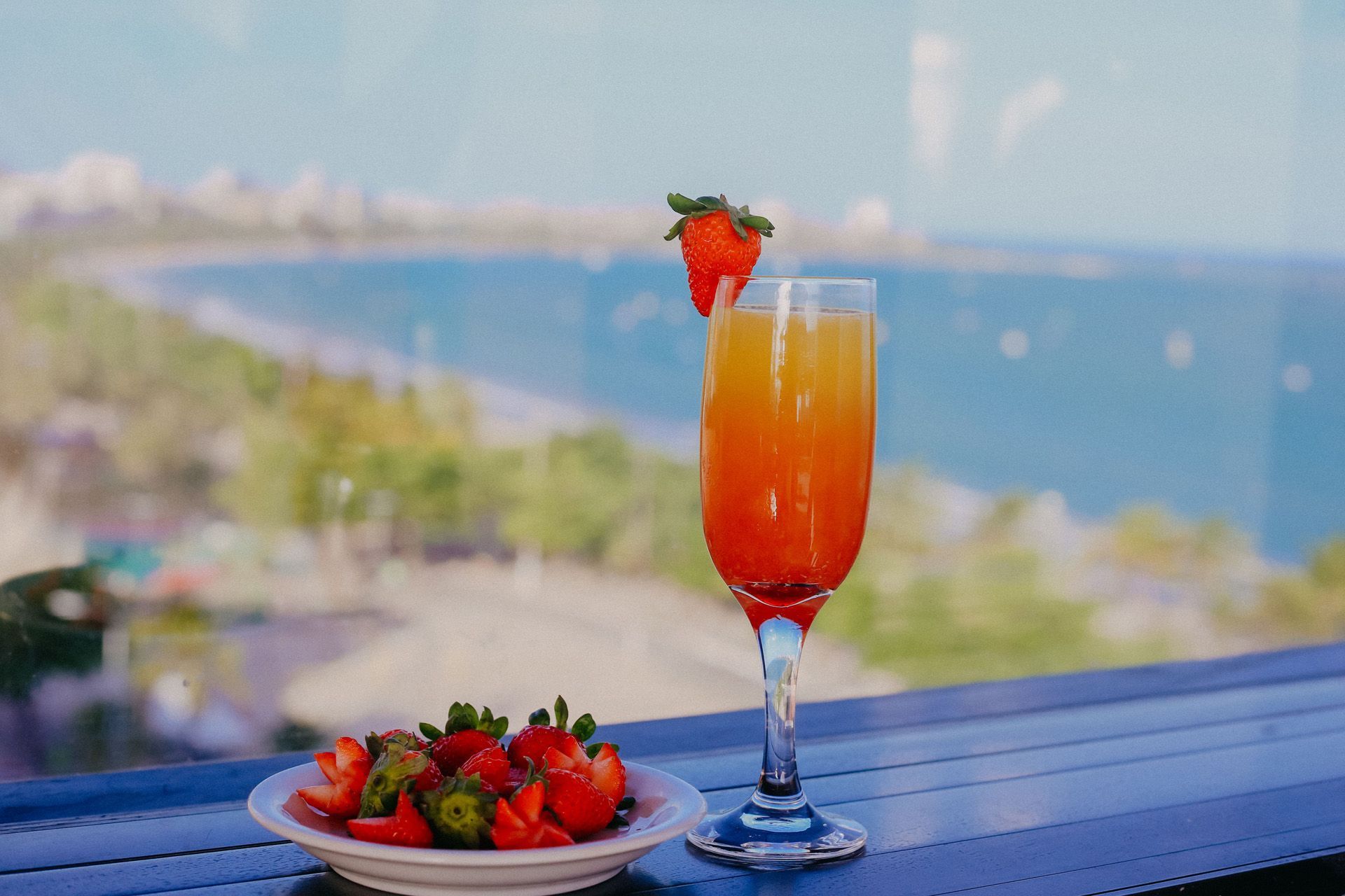 Mesa de café da manhã posta com ovos mexidos, bebidas e doces em um ambiente de restaurante.